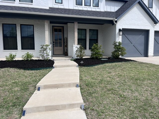 Finished front entry landscaping with fresh mulch beds