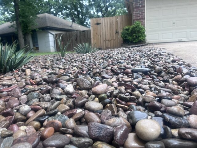 Finished river rock landscaping bed with agave plantings